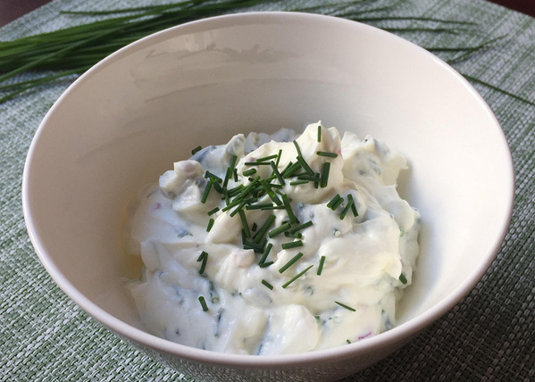 KI generiert: Eine Schüssel mit Kräuterquark, garniert mit frischem Schnittlauch.