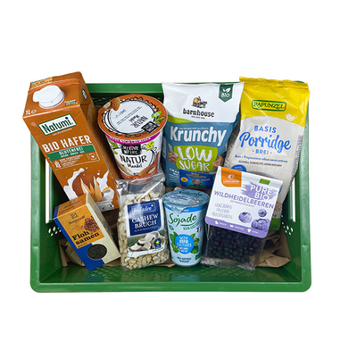 KI generiert: Eine Kiste mit verschiedenen Bio-Lebensmitteln, darunter Haferdrink und Porridge.