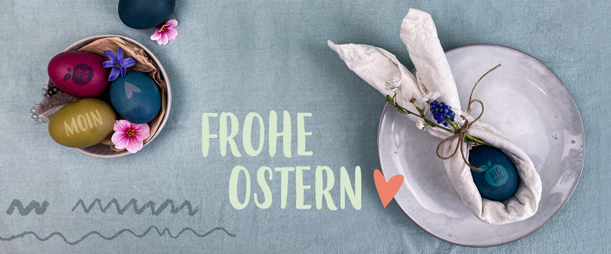 KI generiert: Bunte Ostereier auf einem Tisch, Text: "FROHE OSTERN".