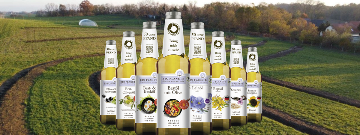 Mehrere Flaschen Bio-Öle von Bio Planète vor einem landwirtschaftlichen Hintergrund. Enthält Text „50 Cent Pfand“.