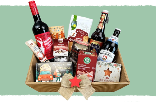 KI generiert: Ein Geschenkkorb mit Wein, Bier und weihnachtlichen Süßigkeiten.