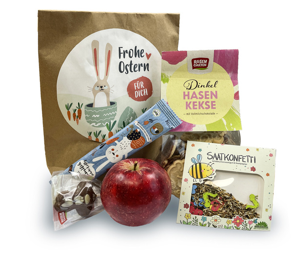 KI generiert: Osterpaket mit Apfel, Schokohase, Keksen und Saatkonfetti. Text: „Frohe Ostern für Dich“, „Dinkel Hasen Kekse“.