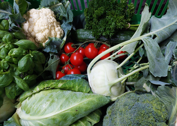 KI generiert: Auf einem Tisch stehen ein Apfel, eine Birne und ein Glas mit orangem Saft. Im Hintergrund befinden sich unscharf ein Stuhl und Büromöbel.