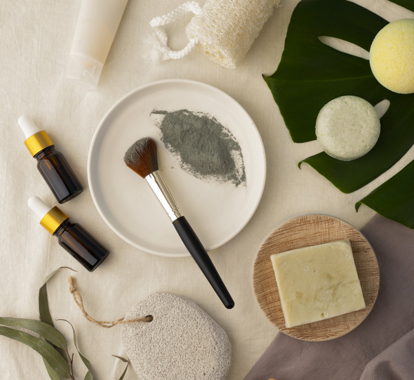 KI generiert: Naturkosmetik-Arrangement mit Pinseln, Fläschchen, Seifen und Blättern auf hellem Hintergrund.