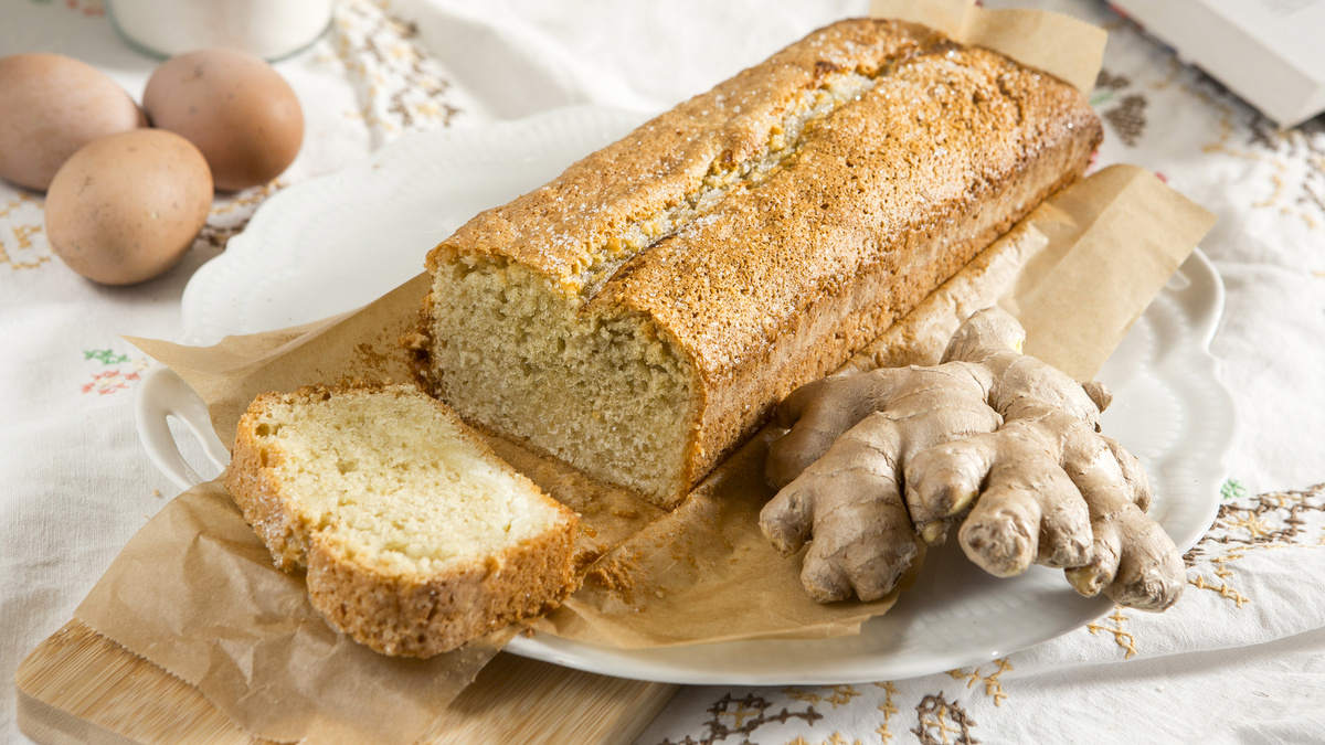 KI generiert: Ein Laib Kuchen auf einem Teller mit Ingwer und Eiern im Hintergrund.