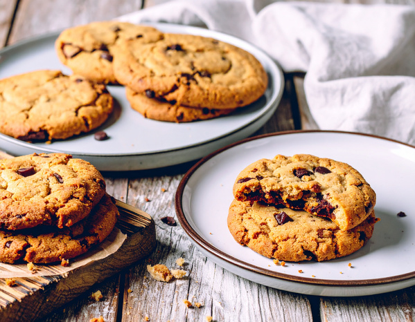 KI generiert: Teller und Brett mit Schokoladenkeksen, einer leicht angebissen.
