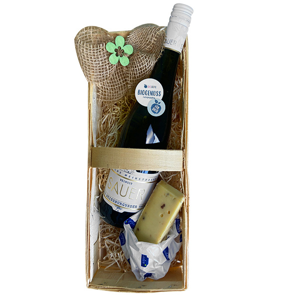 KI generiert: Geschenkkorb mit Weinflasche, Käse und Herzdeko. Text: "BIOGENUSS" auf einem Aufkleber.