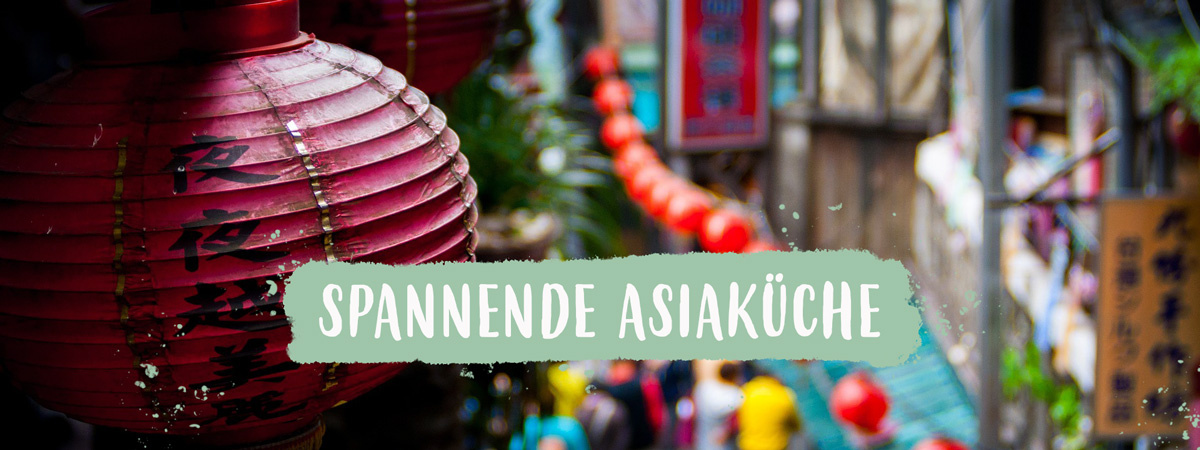 KI generiert: Rote Laternen in asiatischer Gasse, Text: "SPANNENDE ASIAKÜCHE".