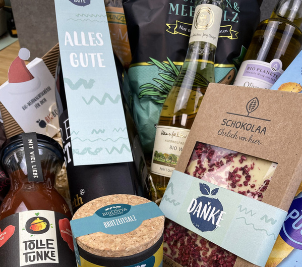 KI generiert: Geschenkkorb mit Lebensmitteln und Getränken. Texte: "ALLES GUTE", "DANKE", "SCHOKOLAA".