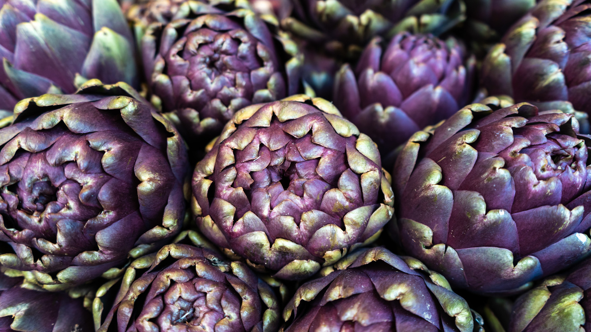 KI generiert: Nahaufnahme von violetten Artischocken mit grünen Spitzen.