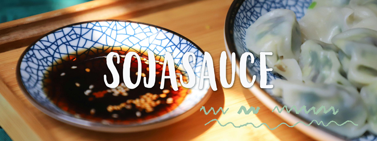 Schälchen mit Sojasauce und asiatischem  Essend rumherum