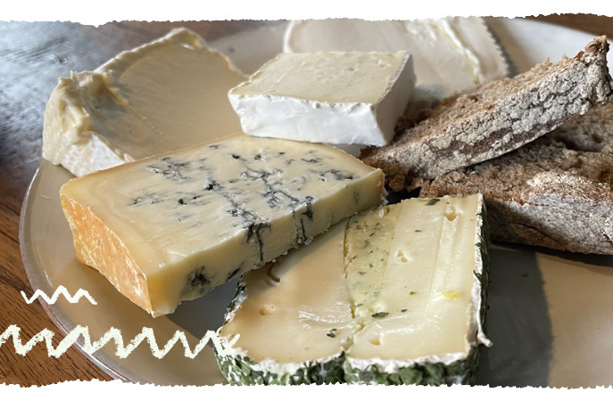 KI generiert: Verschiedene Käsesorten und Brot auf einem Teller.