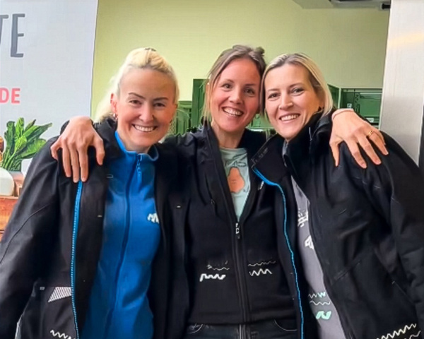 KI generiert: Drei Frauen lächeln und umarmen sich fröhlich.