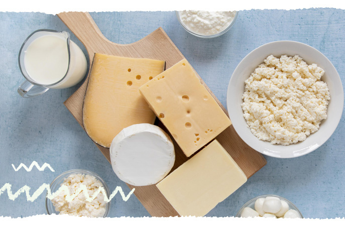 KI generiert: Verschiedene Käsesorten und Milch auf einem Schneidebrett und in Schüsseln arrangiert.